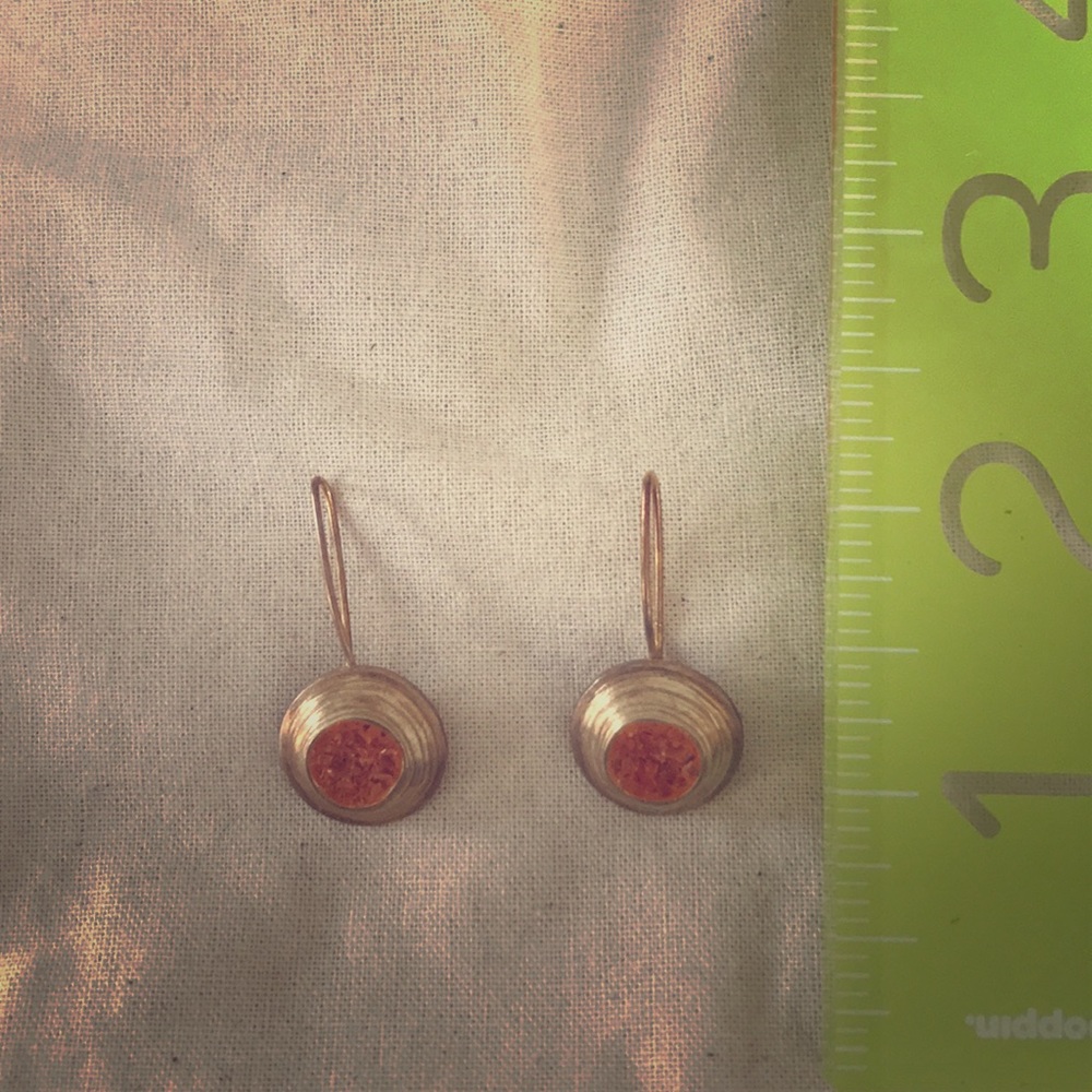 Gold drop earring with orange crushed stone.